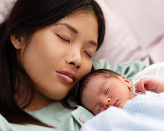 Mother asleep with her baby