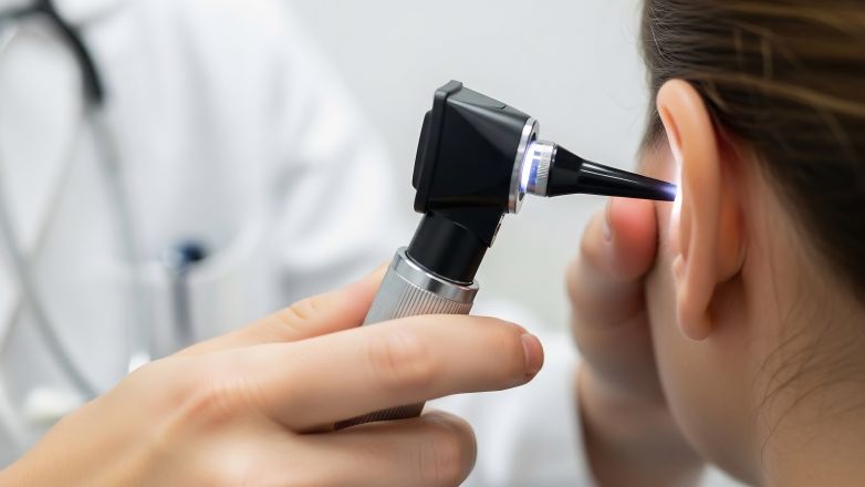 ENT doctor looking into ear of patient